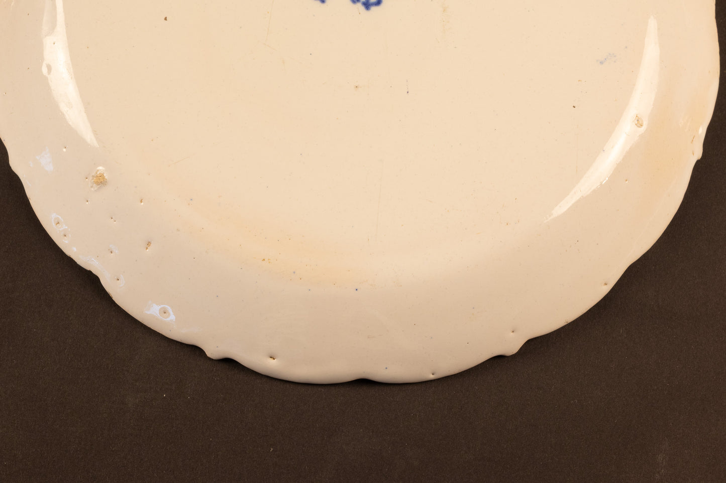 18e-eeuws Delfts blauw aardewerk bord met geschulpte rand en floraal decor